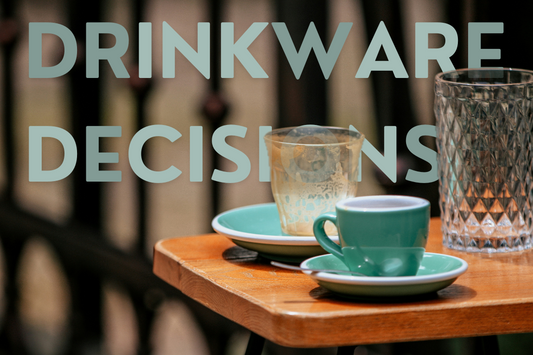 A tall drinking glass, an empty coffee glass and a coffee cup, sitting on a wooden table.