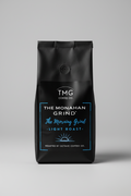 Coffee packaging for TMG Coffee Co. with 'The Monahan Grind' and 'The Morning Grind' text on a black background.
